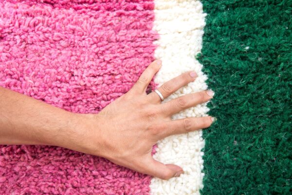 Colorful Moroccan rug with a beautiful abstract pink, green white pattern for a modern living room