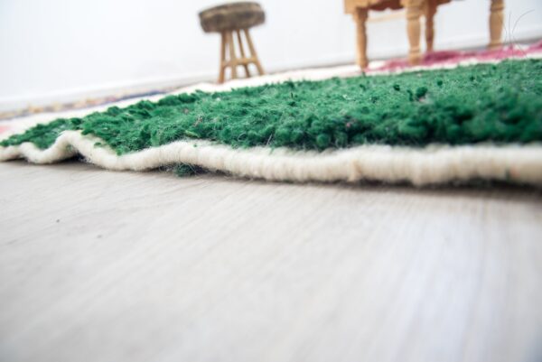 Colorful Moroccan rug with a beautiful abstract pink, green white pattern for a modern living room